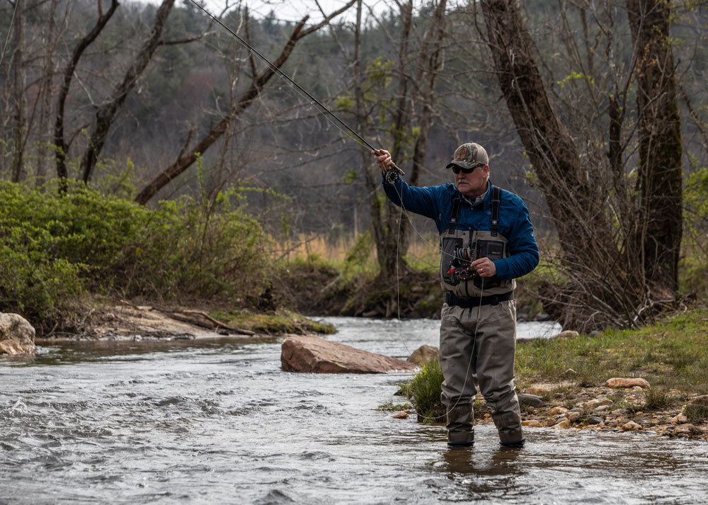 Fly fisherman using a spinning reel with yellow line in a close up